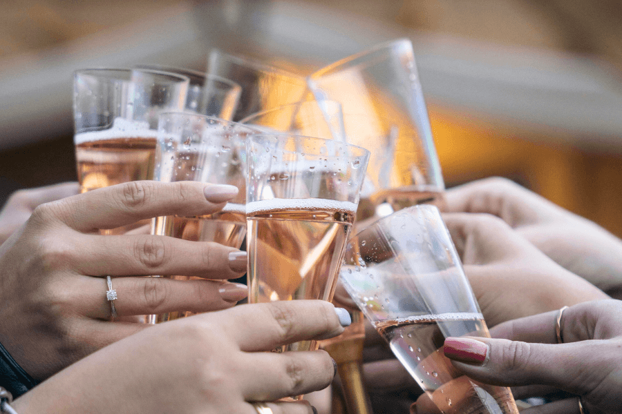 Several hands holding champagne glasses in a toast.